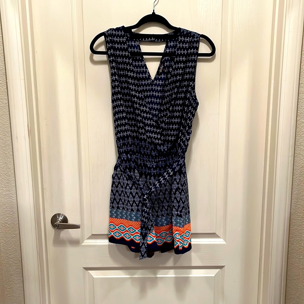Sleeveless tie waist Aztec style print V-neck romper with pockets & button back.